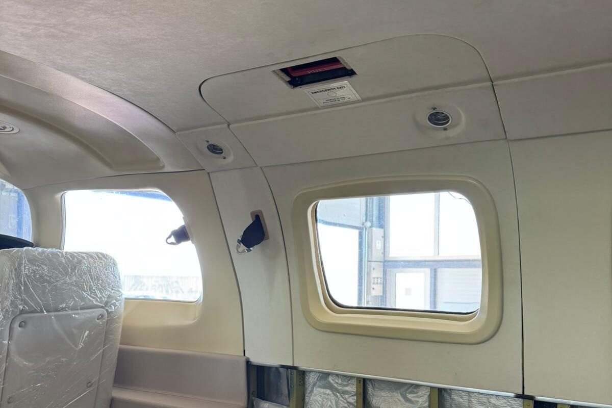 Refit in progress: foil-faced insulation blankets pinned to the fuselage frames below the cabin window, new headliner and window reveal already fitted above.